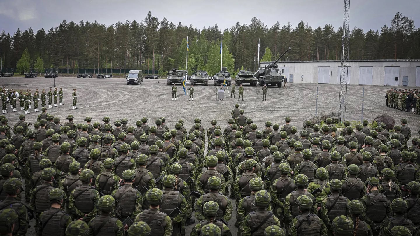 Uppställning i Boden med hundratals soldater framför svenska flaggan