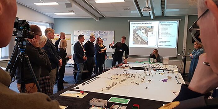 En grupp människor står runt ett stort bord. På bordet ligger en stor Gotlandskarta.